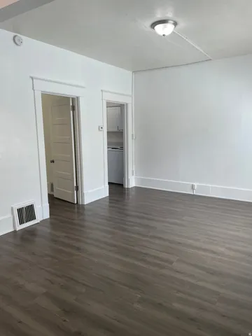 Spacious interior featuring wood-finish flooring, white walls, and a ceiling-mounted light fixture