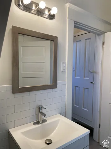 Bathroom vanity featuring a white integrated sink, chrome single-handle faucet, and wood-frame mirror