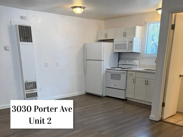 Kitchen area featuring white cabinetry with matching appliances, including a refrigerator, range, and microwave