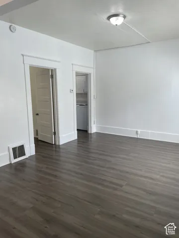 Spacious interior featuring wood-finish flooring, white walls, and a ceiling-mounted light fixture