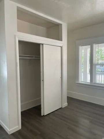 Wardrobe closet with sliding doors and integrated upper storage