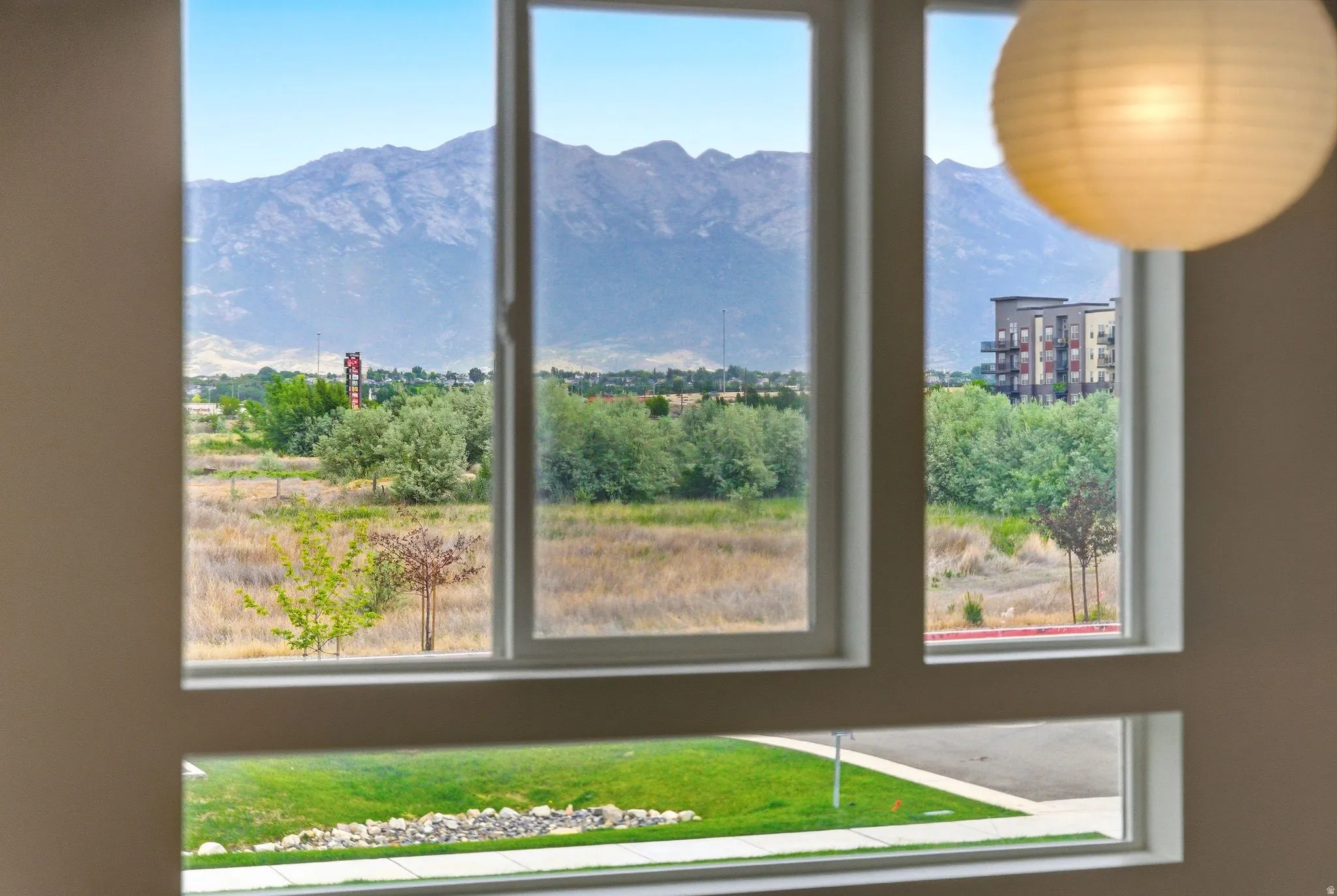Expansive multi-pane window framing a natural landscape with distant mountains