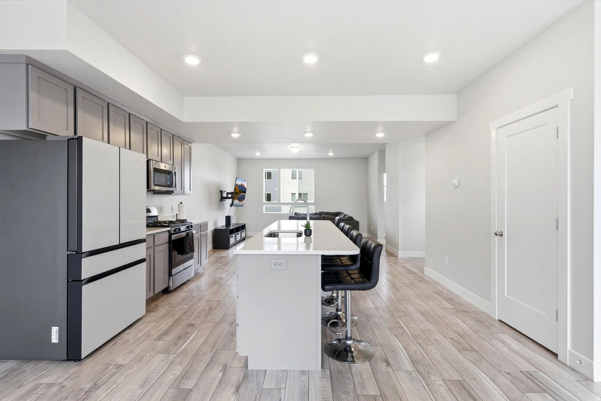 Spacious open-concept living area featuring wood-finish flooring and recessed lighting