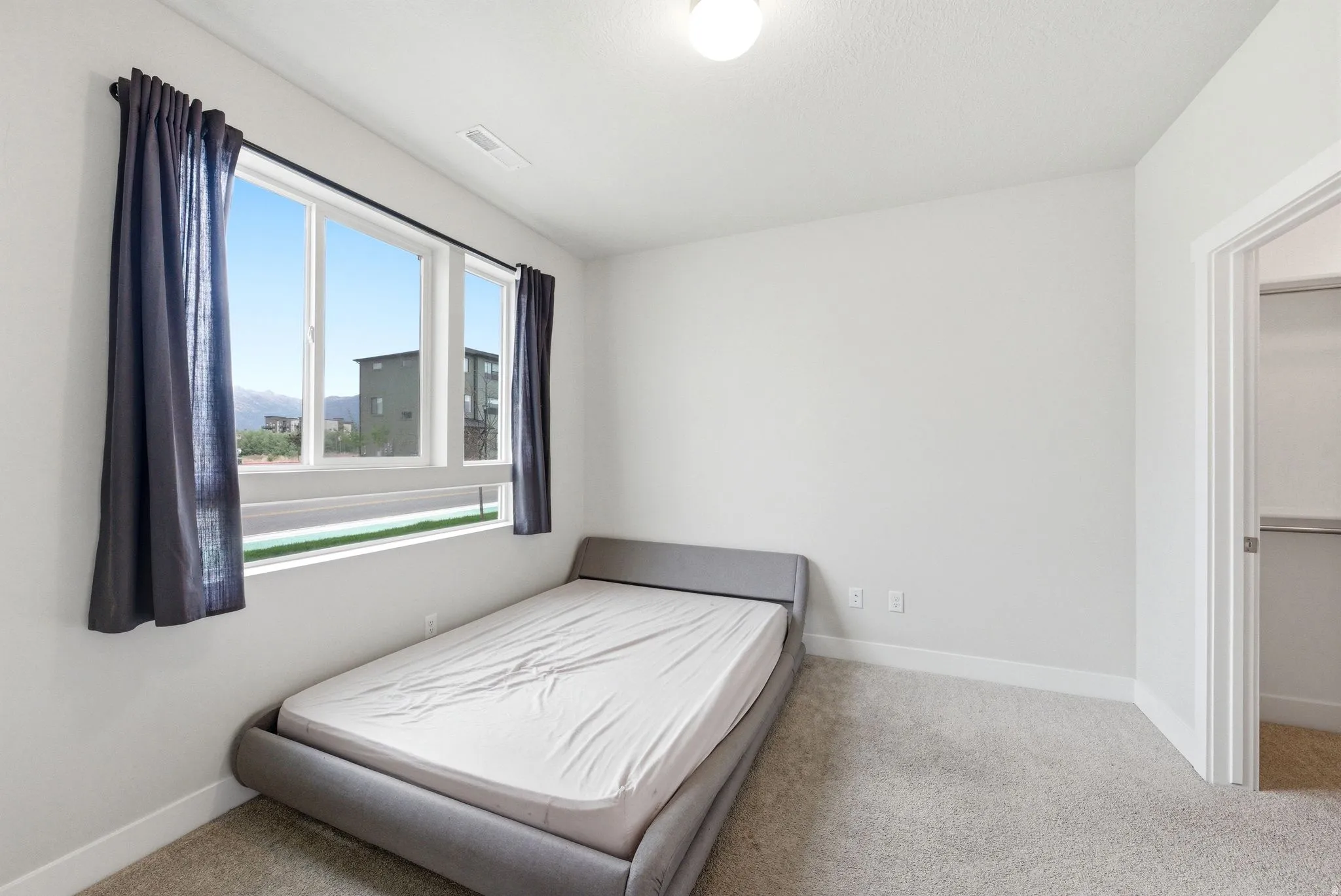 Room featuring light gray wall paint, white baseboards, and neutral carpet