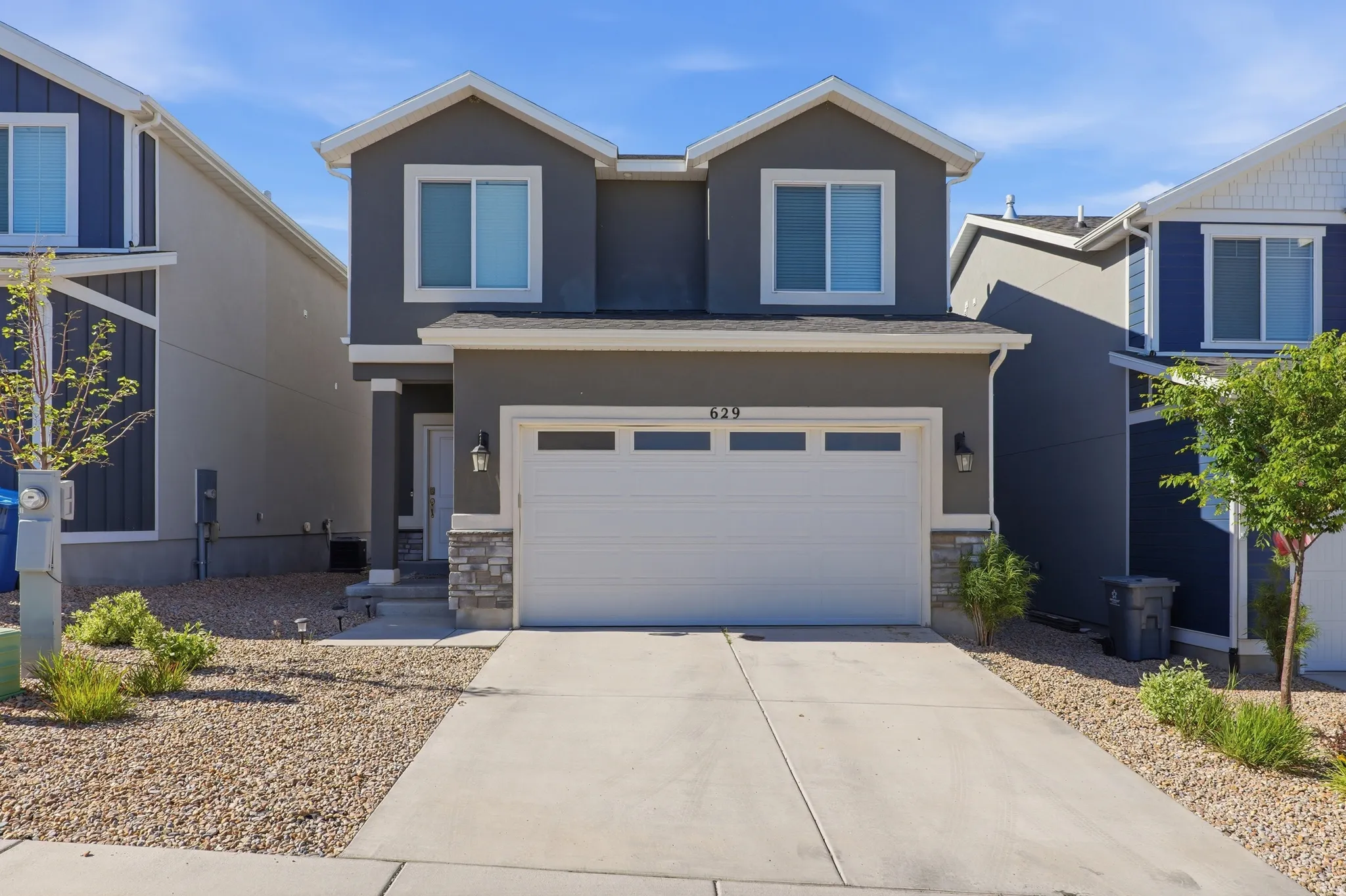Contemporary two-story exterior with a gray stucco finish and white trim