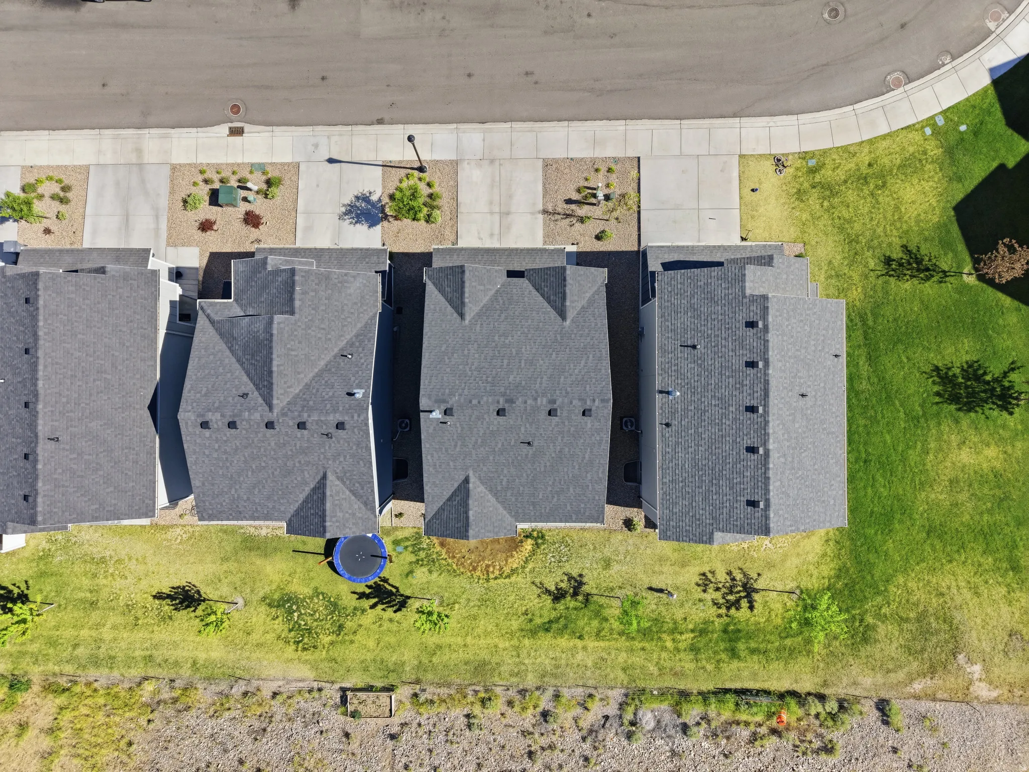 Row of residential properties featuring dark gray shingled roofs