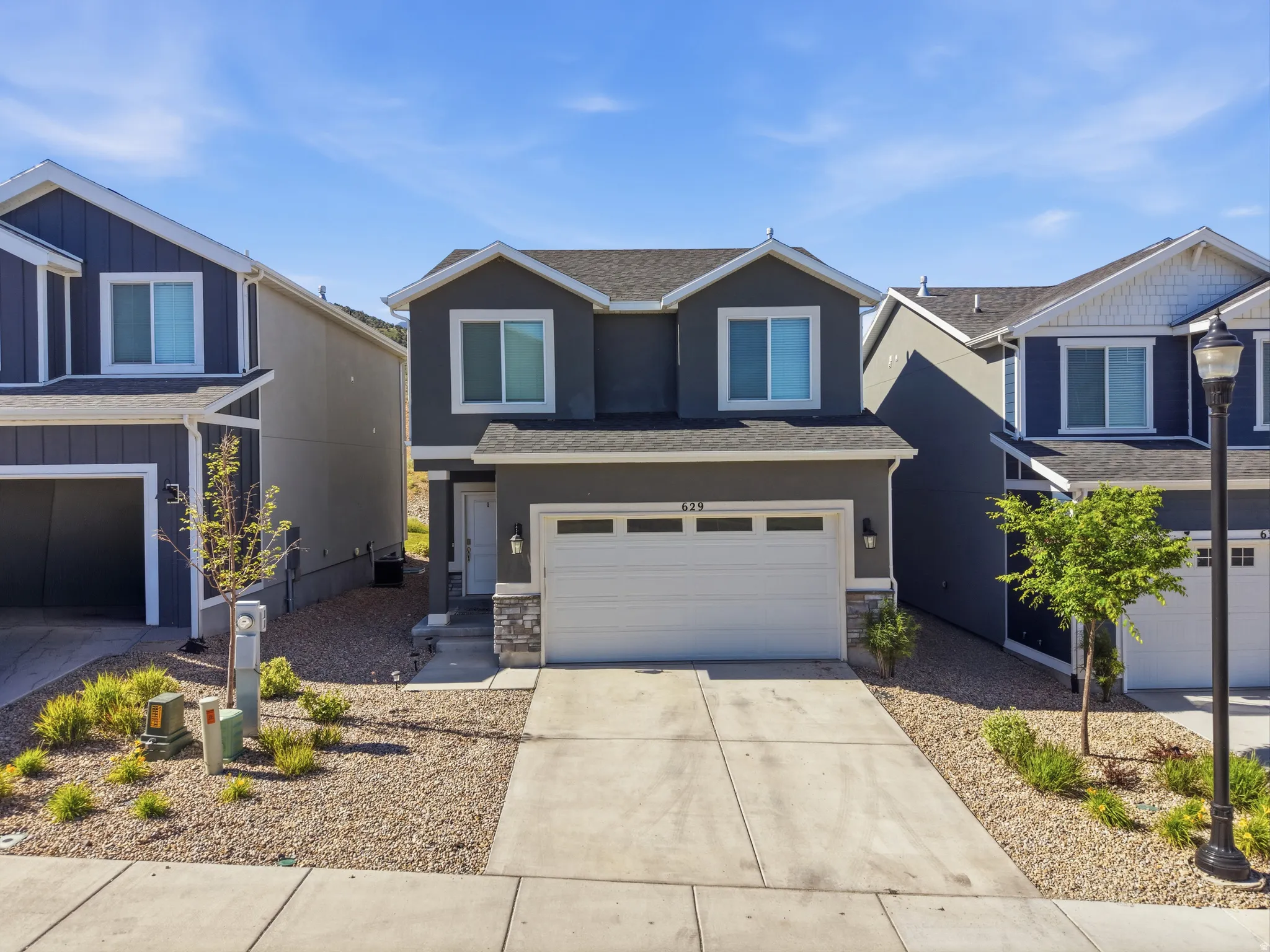 Contemporary two-story residence with a dark gray exterior and white trim