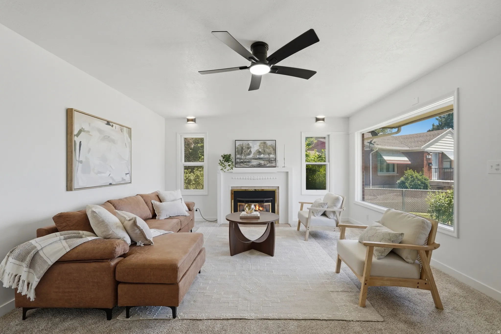 Living area featuring a fireplace with a white mantel, ceiling fan, recessed lighting, and large picture windows