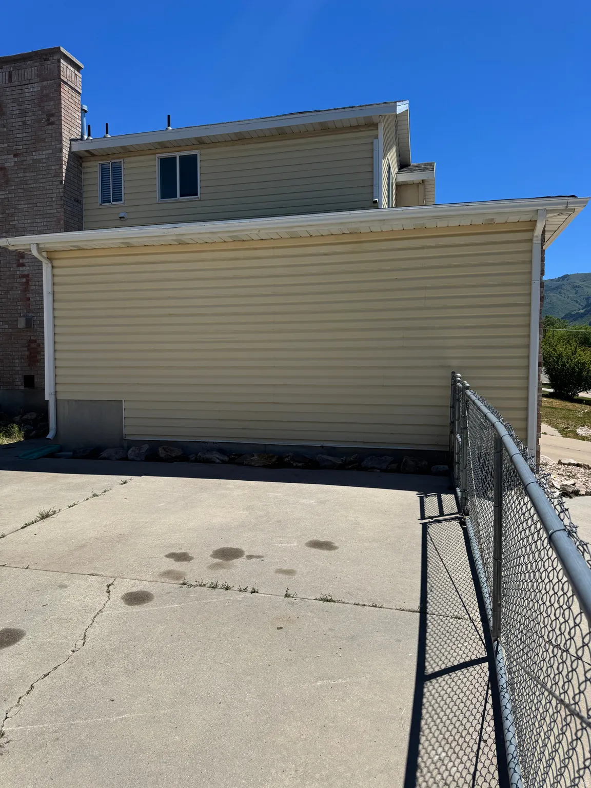 Beige horizontal siding exterior with a brick chimney accent