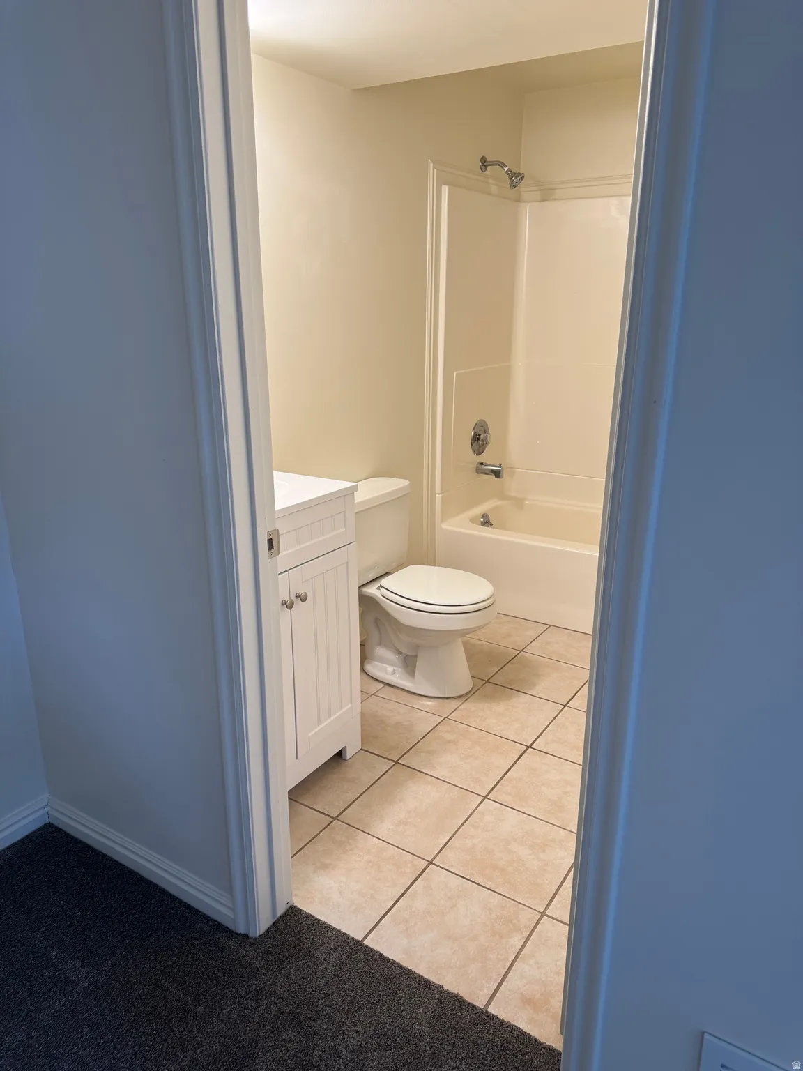 Bathroom featuring a white vanity cabinet, a white toilet, and a white bathtub with an integrated shower
