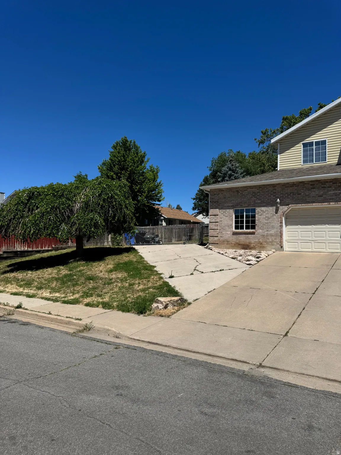 Exterior featuring brick and siding facade, an attached garage, and a concrete driveway