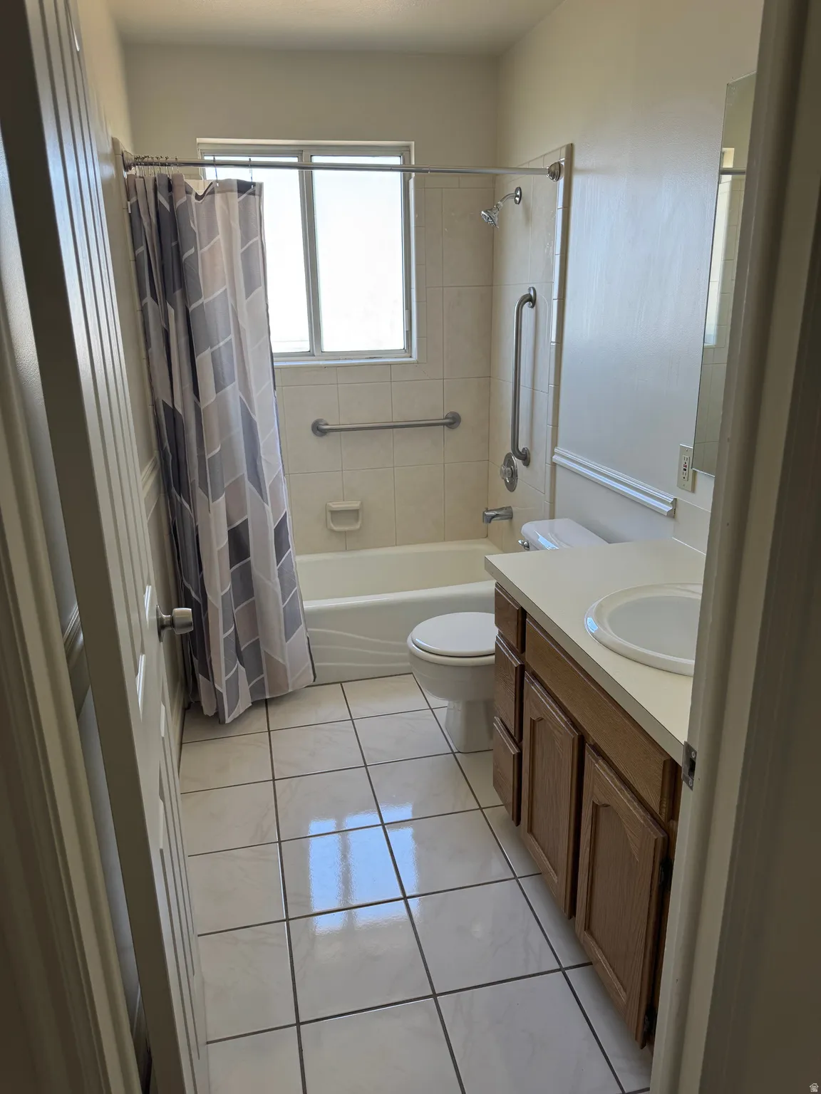 Bathroom featuring a single-sink vanity with wood-finish cabinetry, a white countertop, and a white toilet