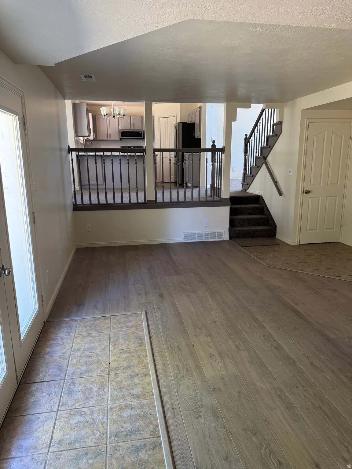 Open-concept living area featuring wood-finish flooring and a tiled entry