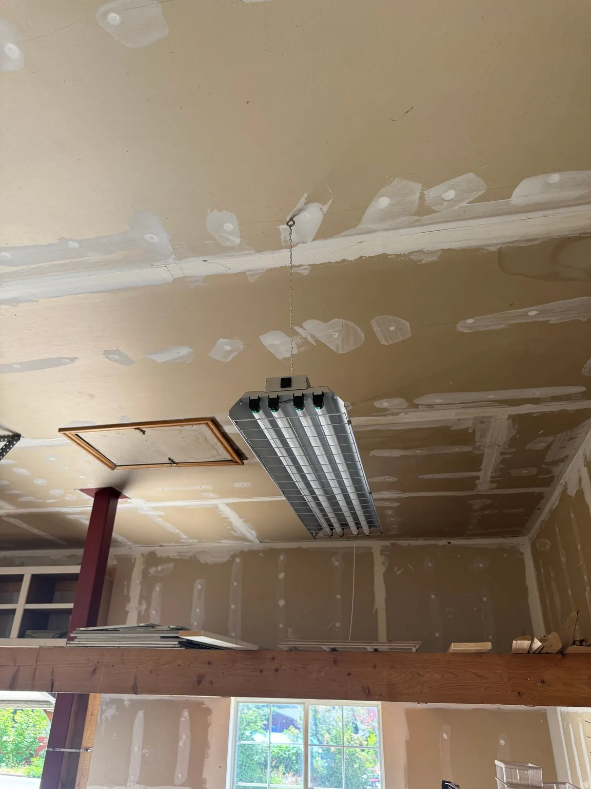 Exposed wood beam supporting an upper-level floor with a red support column