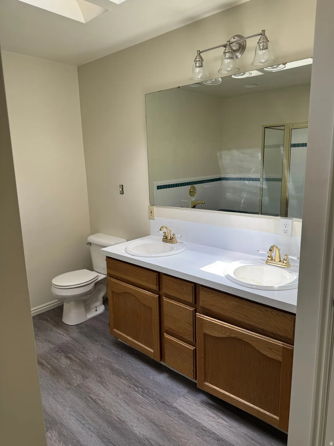 Dual vanity featuring white countertops, undermount sinks, and gold-tone fixtures