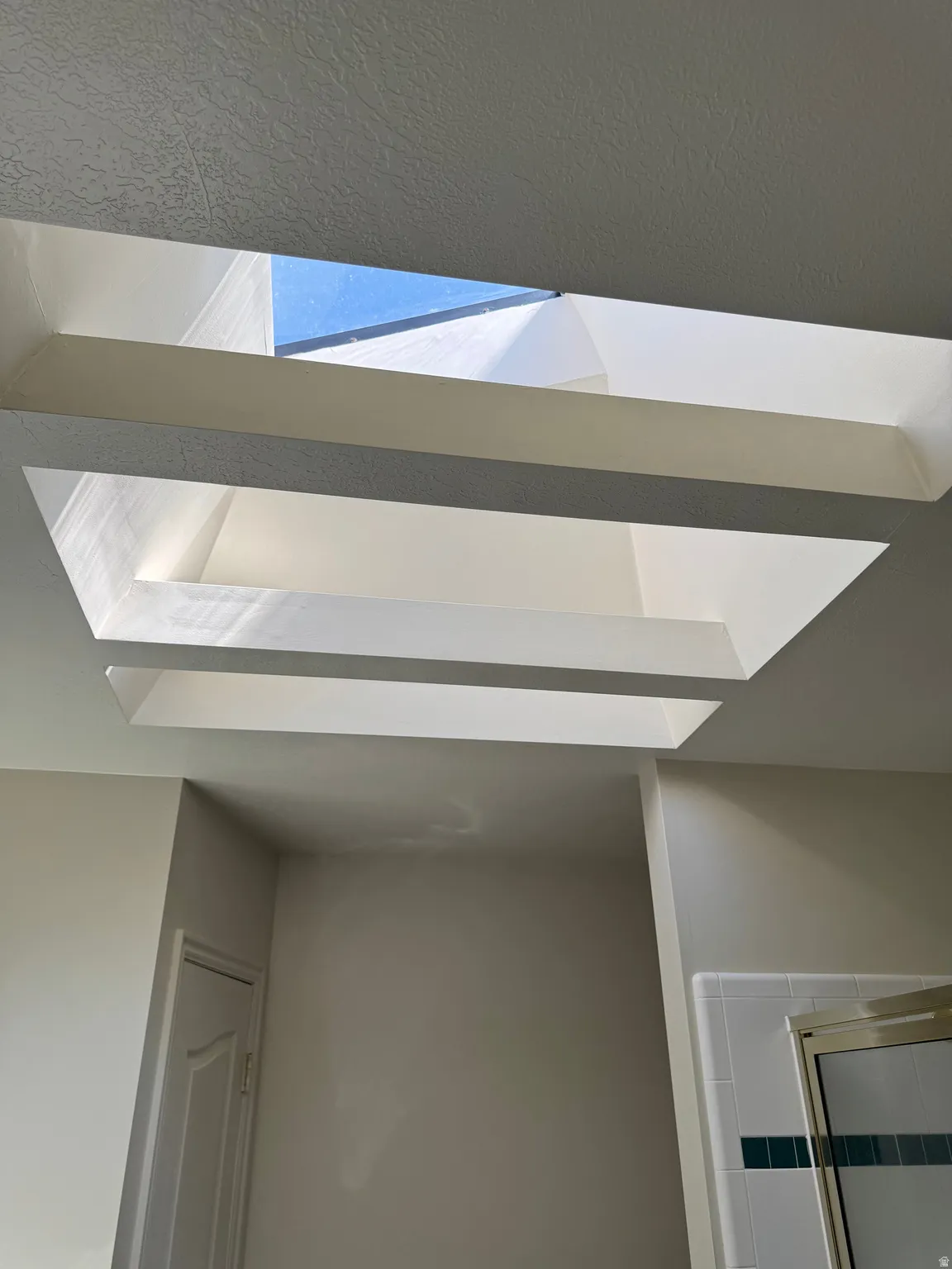 Recessed skylight feature with a rectangular opening and tiered light well, providing natural illumination