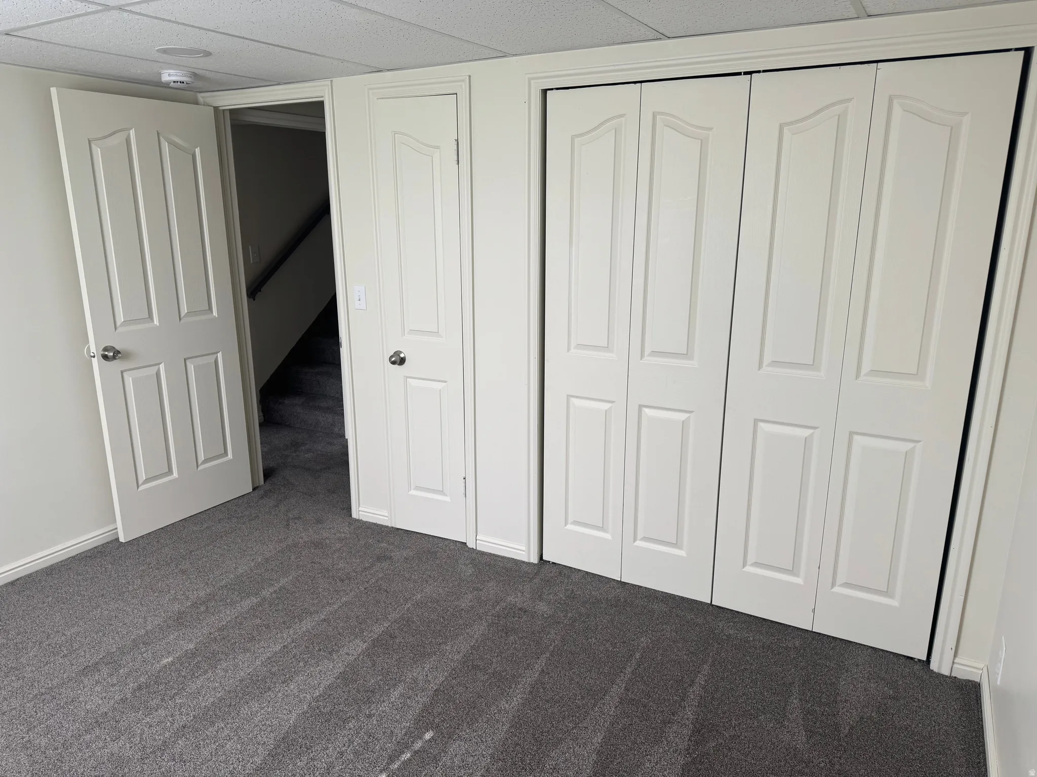 Gray textured carpeting complements the neutral wall color