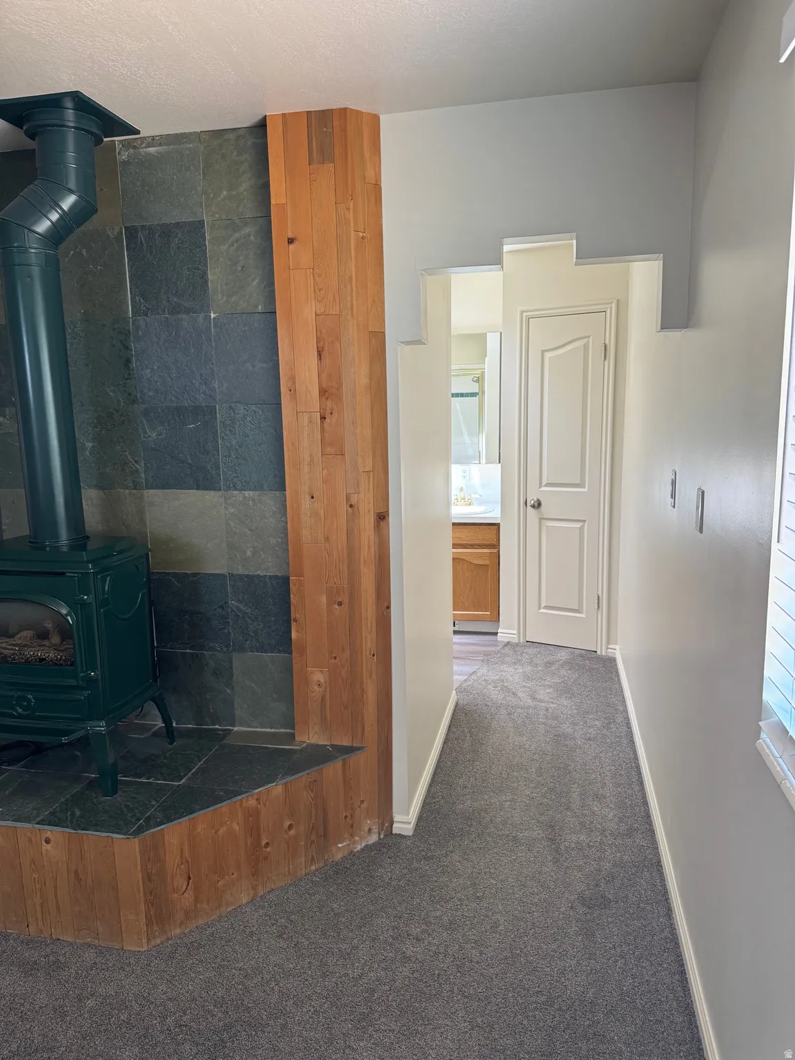 Recessed wood-burning stove with a slate tile surround and wood plank accents