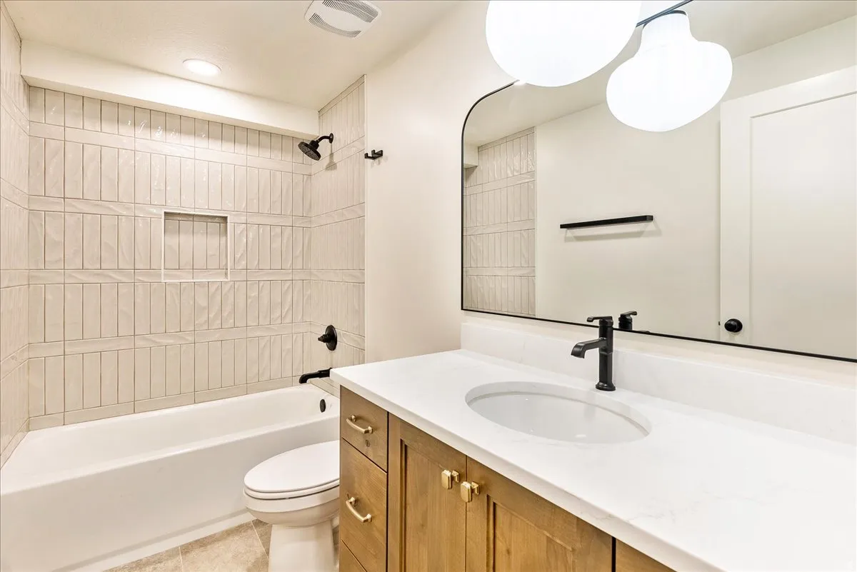 Bathroom featuring a tub/shower combination with textured vertical wall tile and a recessed niche