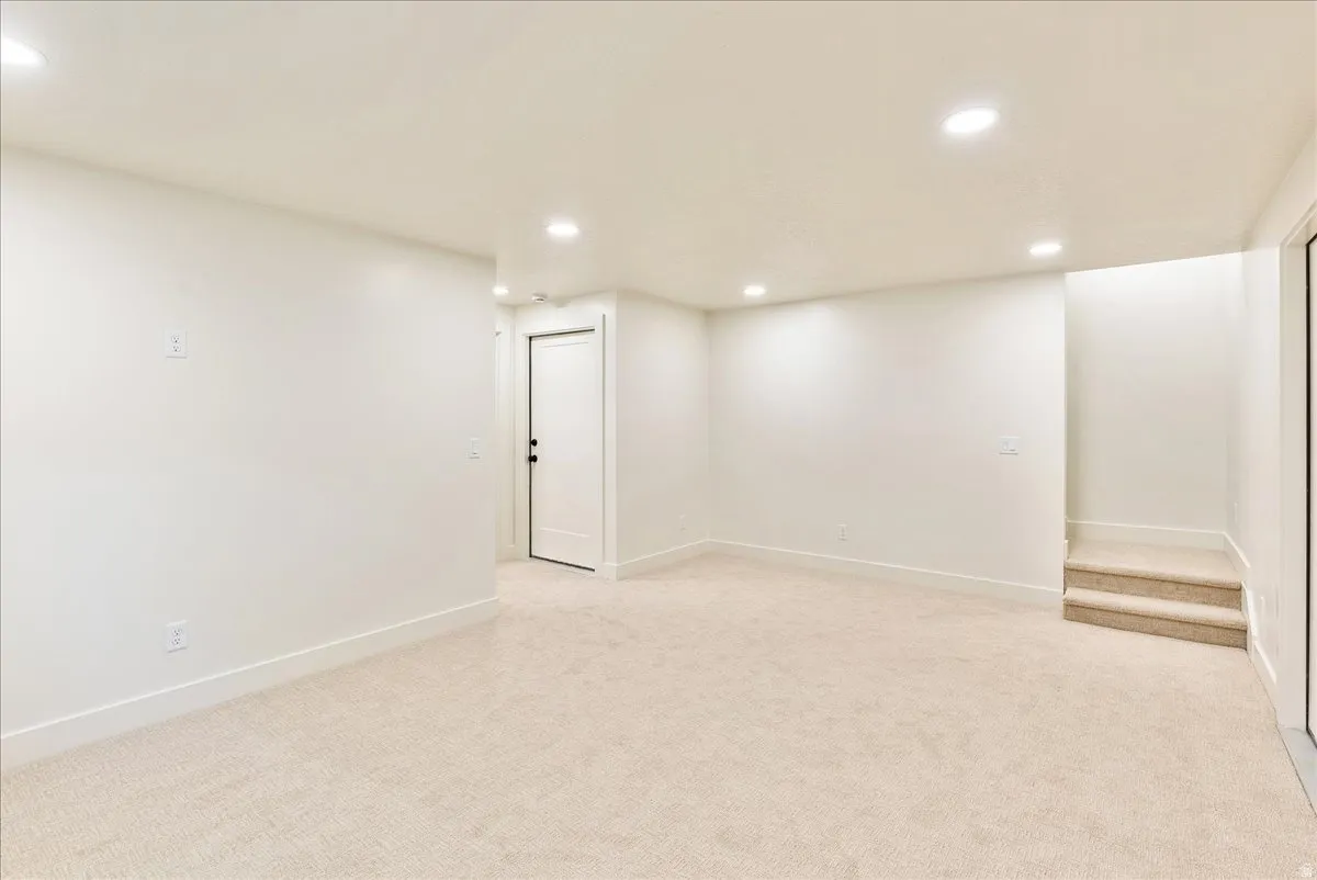 Spacious room featuring neutral carpeting, recessed lighting, white walls, and bright white trim