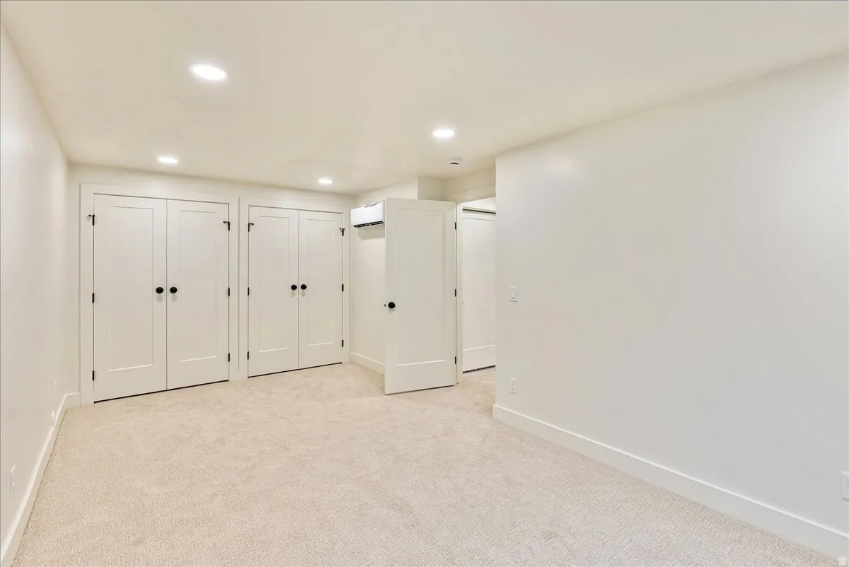 Neutral-toned carpeting and recessed ceiling lighting complement the light wall finishes