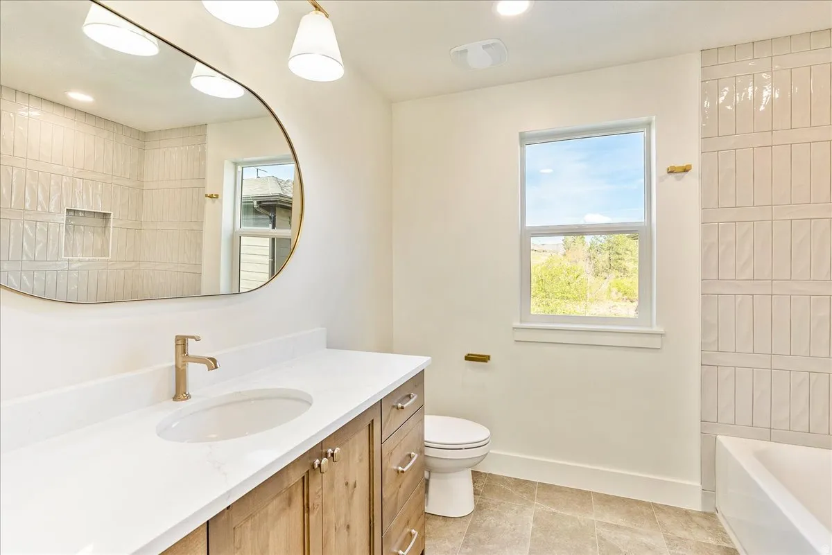 Bathroom featuring a wood-finish vanity with a white countertop and undermount sink