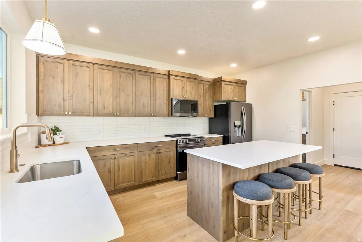 Kitchen featuring wood-finish cabinetry, white countertops, and a subway tile backsplash