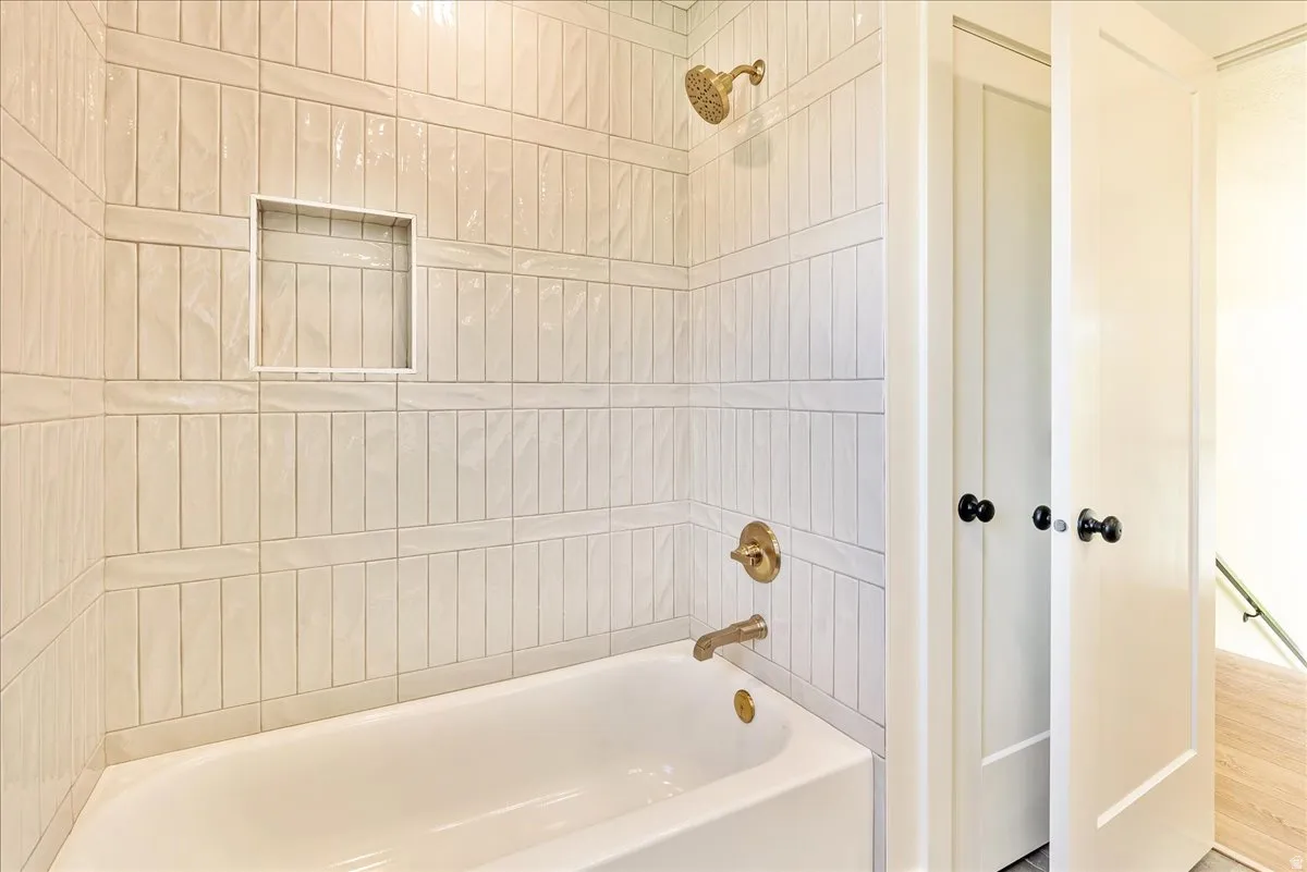 Bathtub with vertical tile surround and integrated shower niche