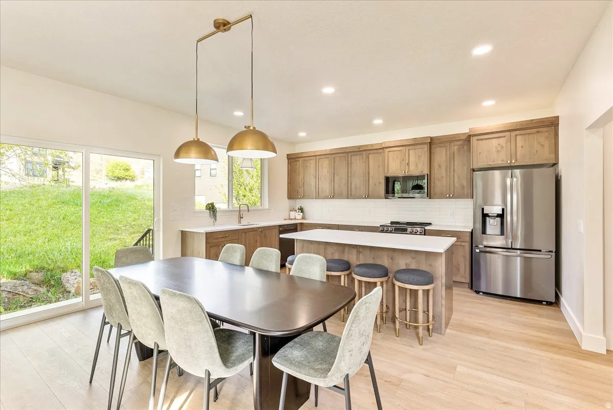 Open-concept kitchen and dining area featuring wood-finish flooring