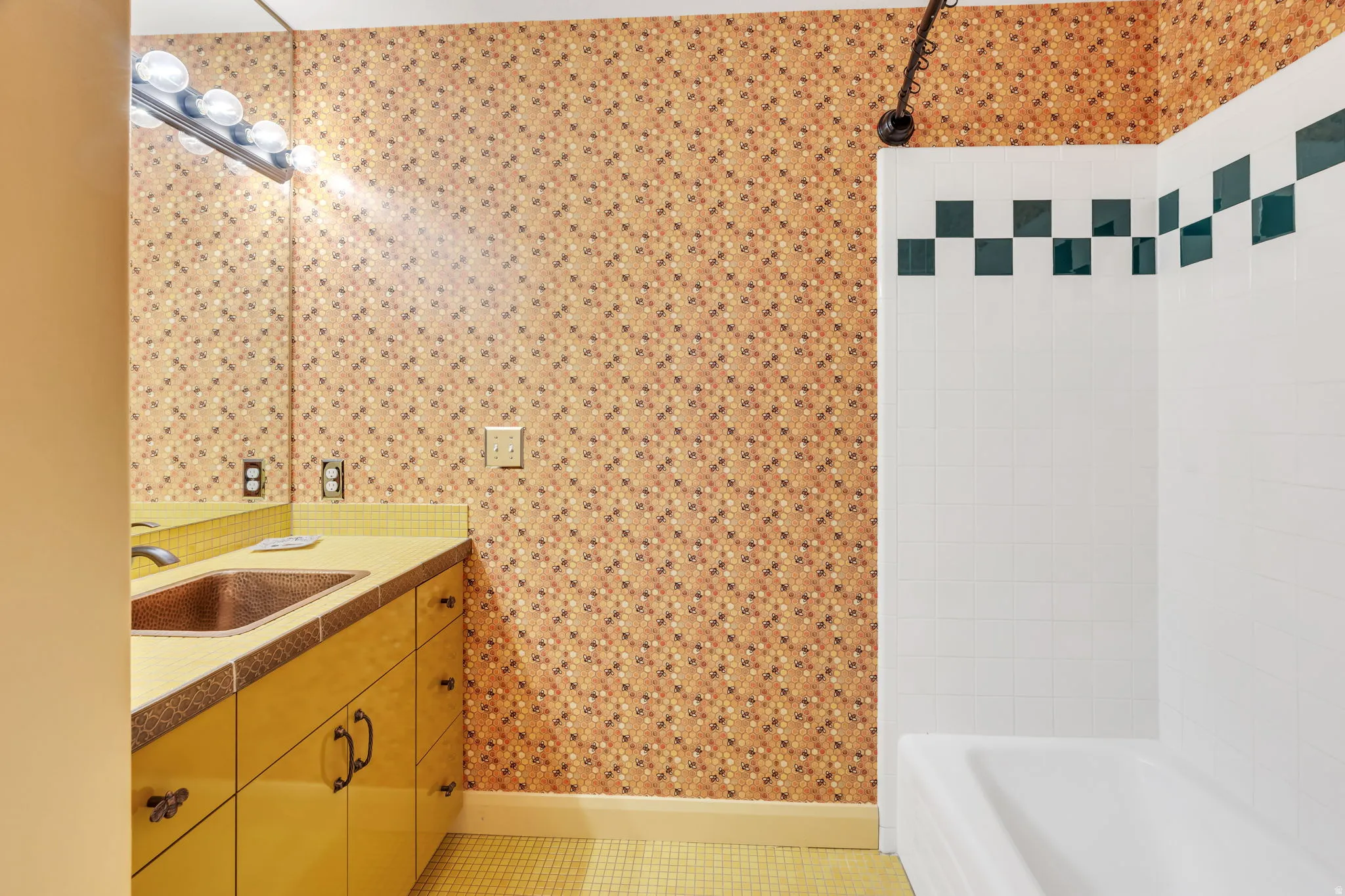 Bathroom featuring a vanity with a copper-toned sink, a full-width mirror, and a wall-mounted light fixture