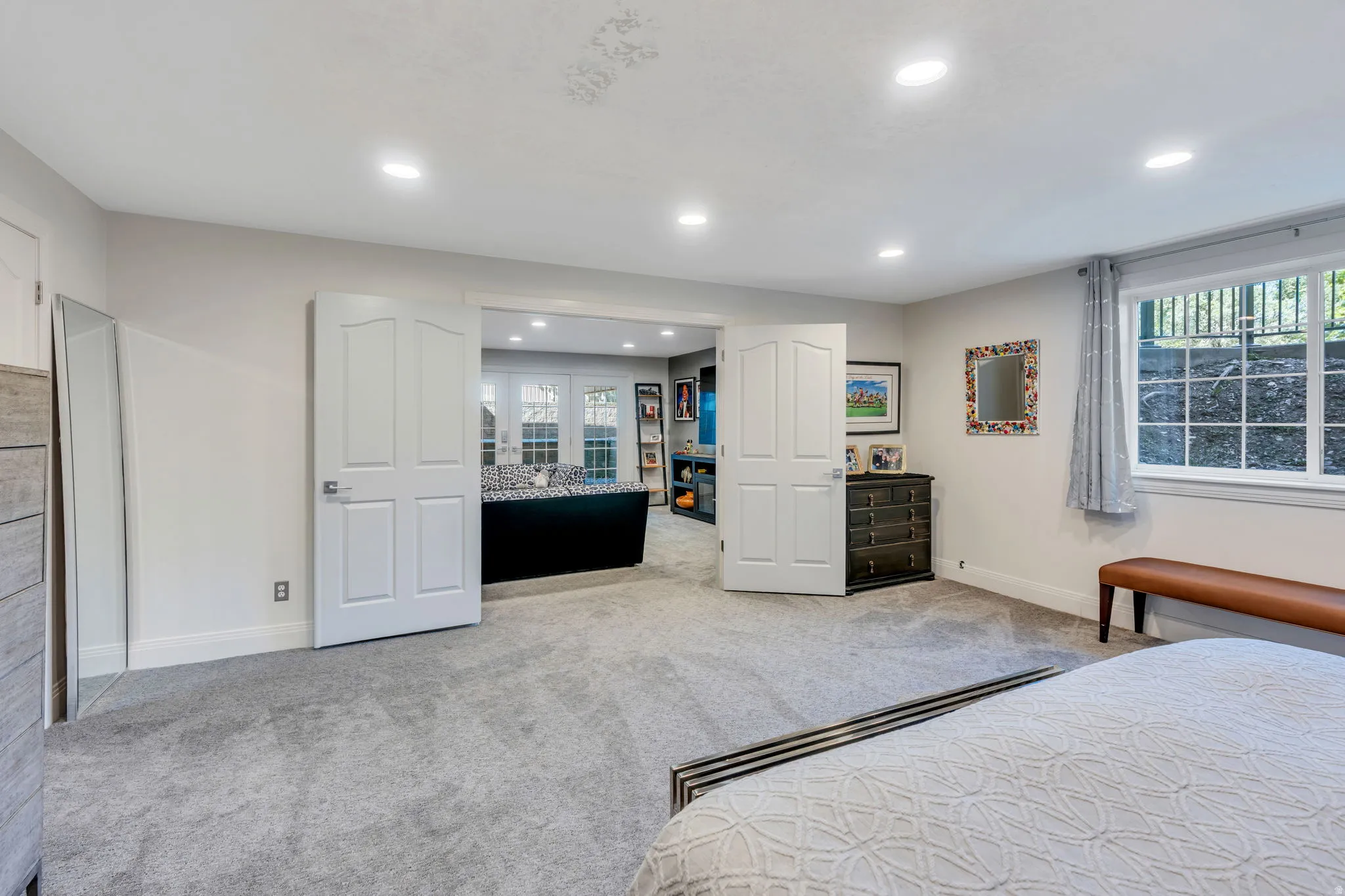 Carpeted room with recessed lighting and a window featuring natural light