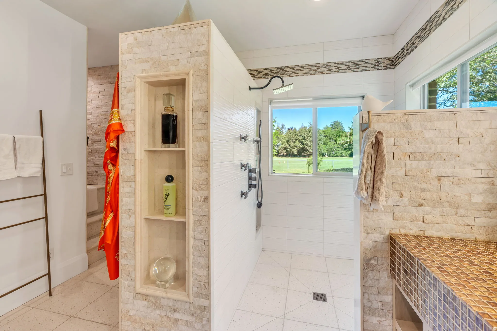 Walk-in shower with a rainfall showerhead and a tiled bench