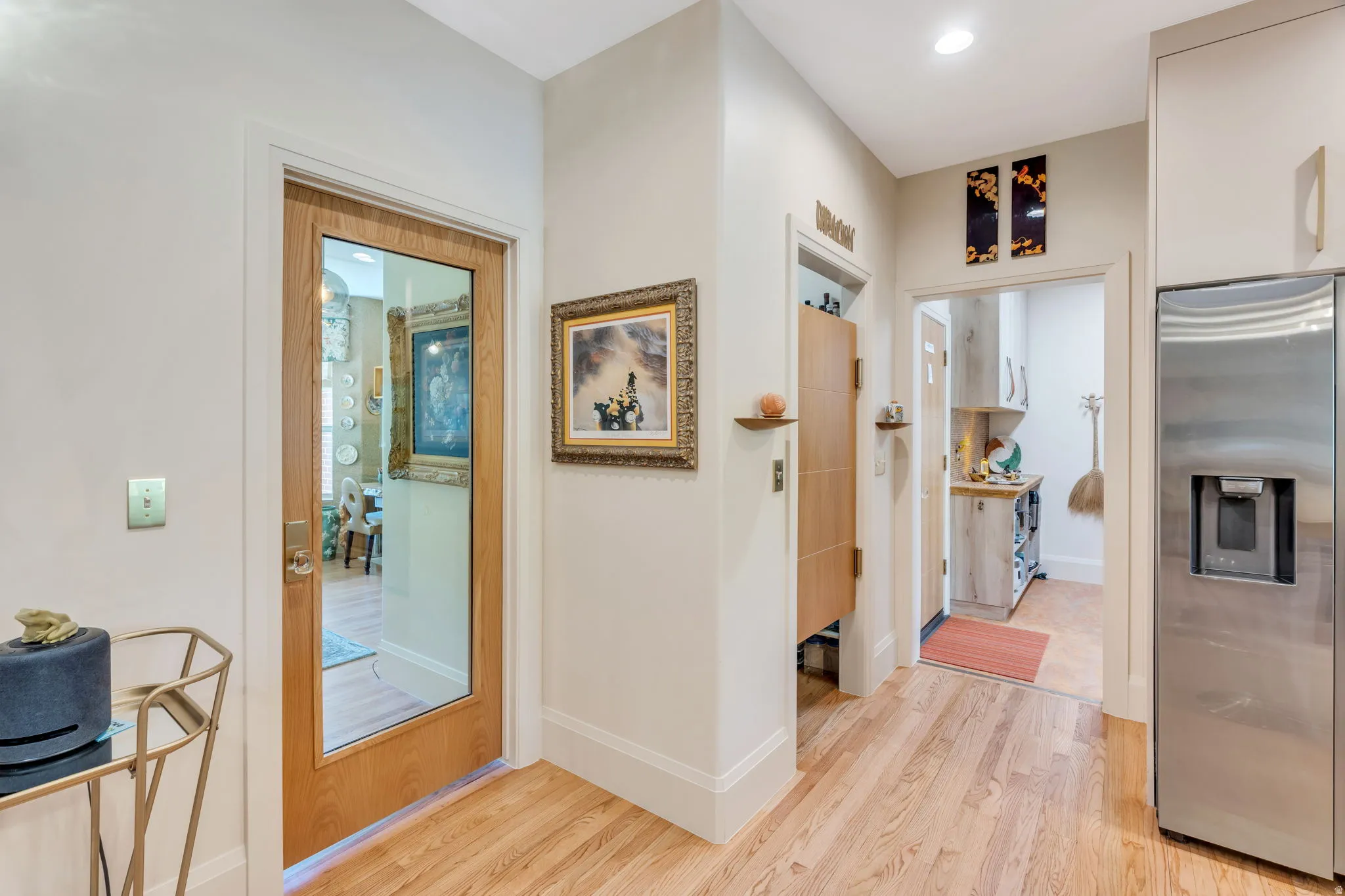 Hardwood-style flooring throughout, featuring a stainless steel French door refrigerator with ice and water dispenser