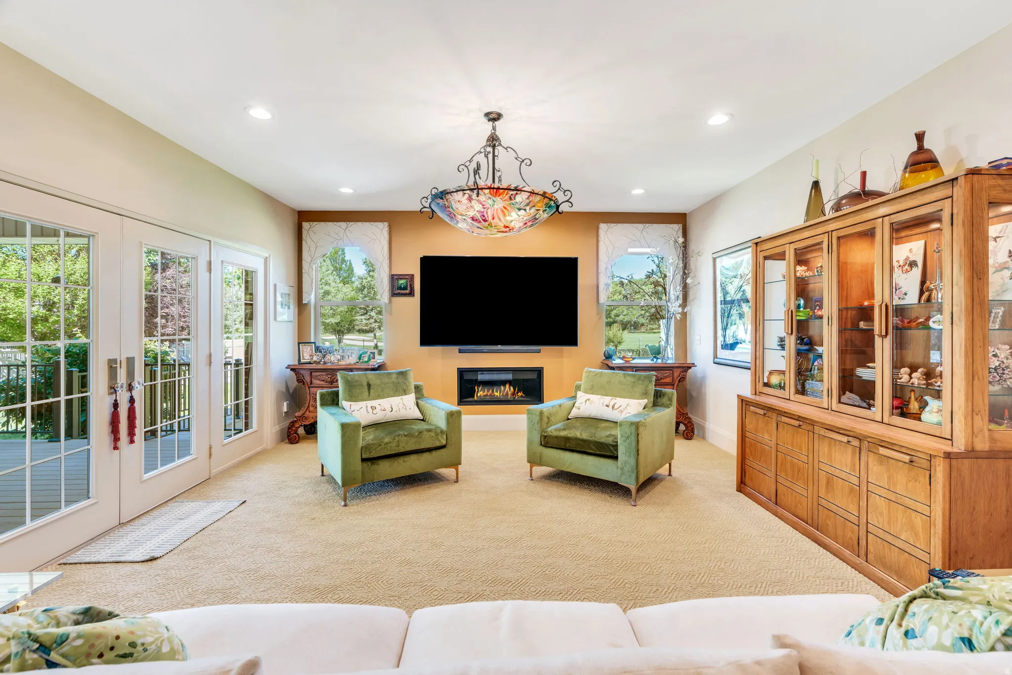 Living area featuring plush carpeting, dual French doors with glass panels, recessed lighting, and a modern wall-mounted fireplace