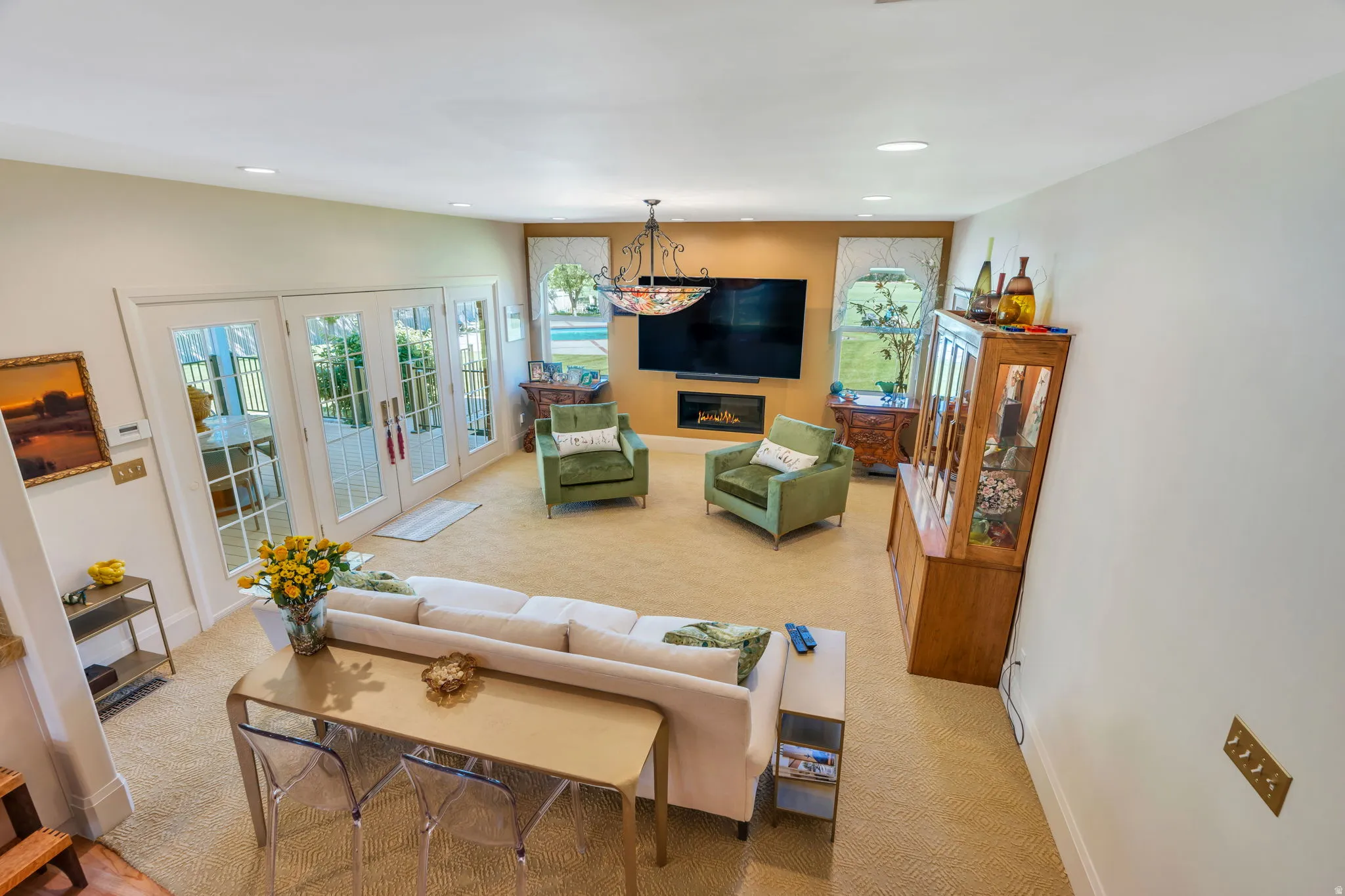 Spacious living area featuring light-toned carpeting and recessed lighting
