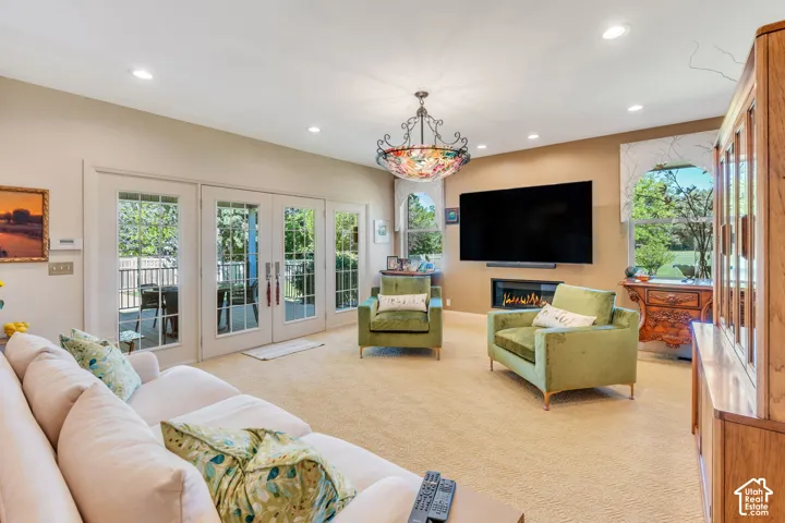 Living space featuring multiple sets of glass-paneled French doors, recessed lighting, and a decorative ceiling fixture