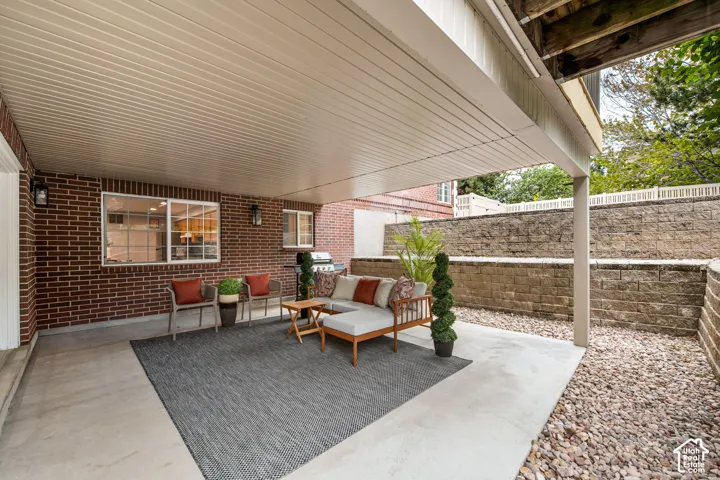 Covered patio with a concrete surface, brick exterior, and recessed lighting