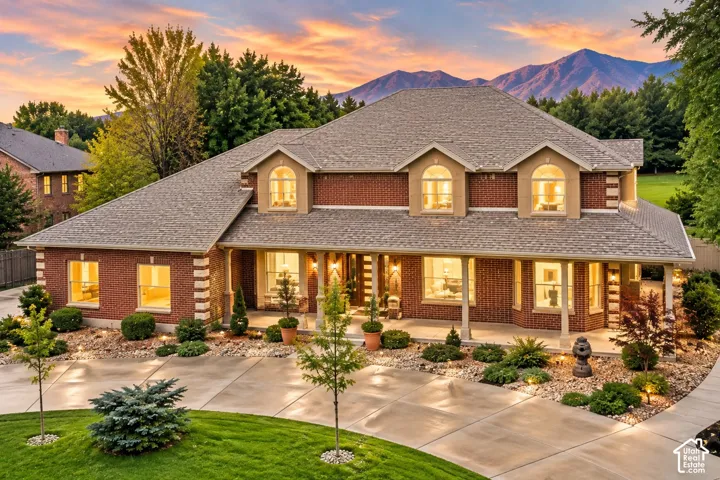 Red brick exterior with stone accents and multiple dormer windows, featuring a multi-pitched roofline