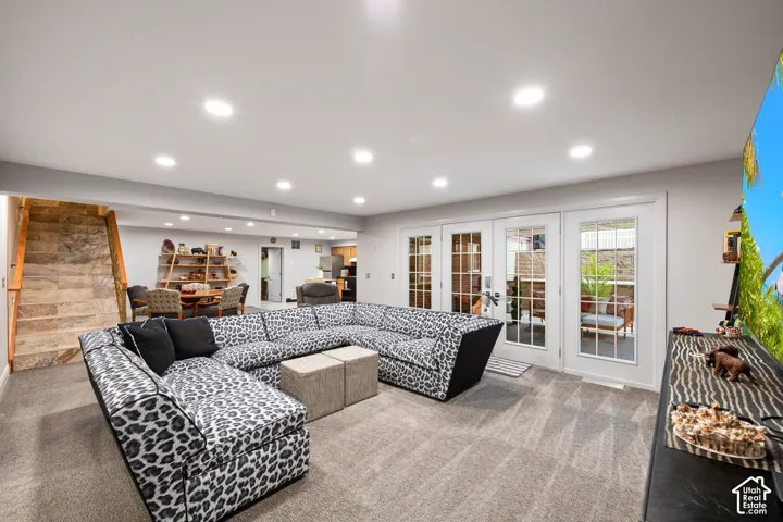 Recessed lighting, carpet flooring, a stone-clad staircase, and white French doors. Walkout basement