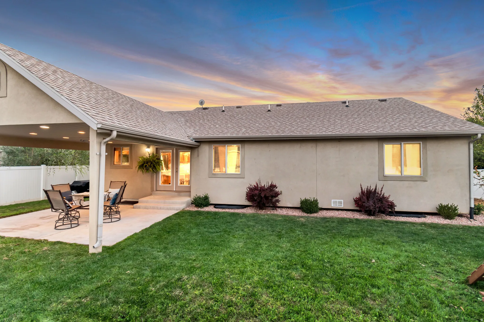 Spacious backyard featuring a covered patio with recessed lighting, a concrete patio surface, a manicured lawn, and mature landscaping