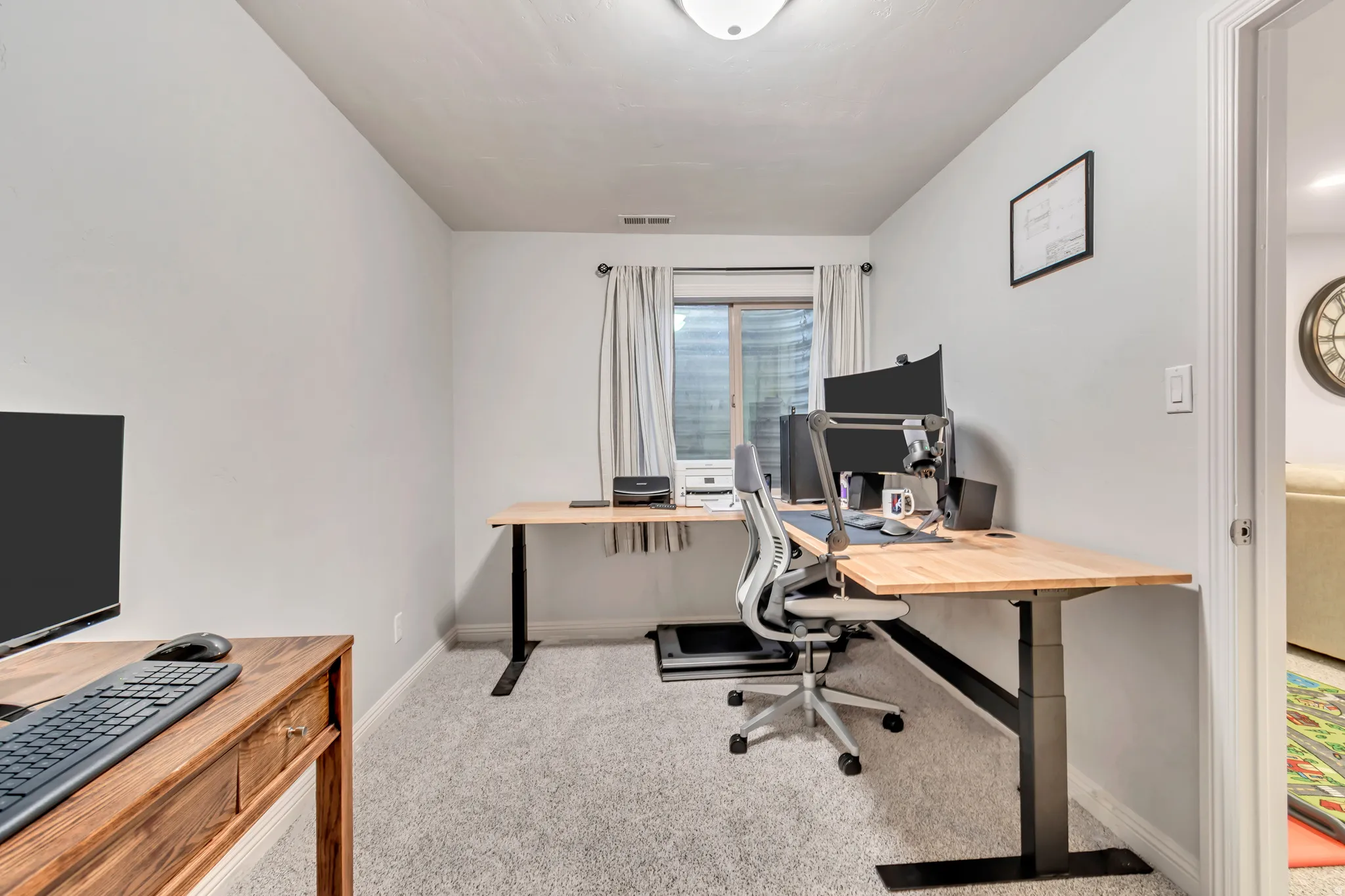 Carpeted room with light gray walls, a window with horizontal blinds, and a built-in overhead light fixture