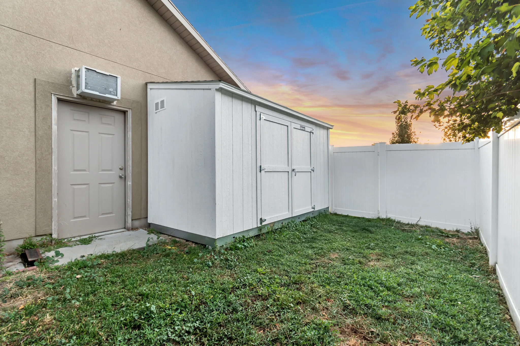 Private outdoor space featuring a white storage shed and perimeter fencing