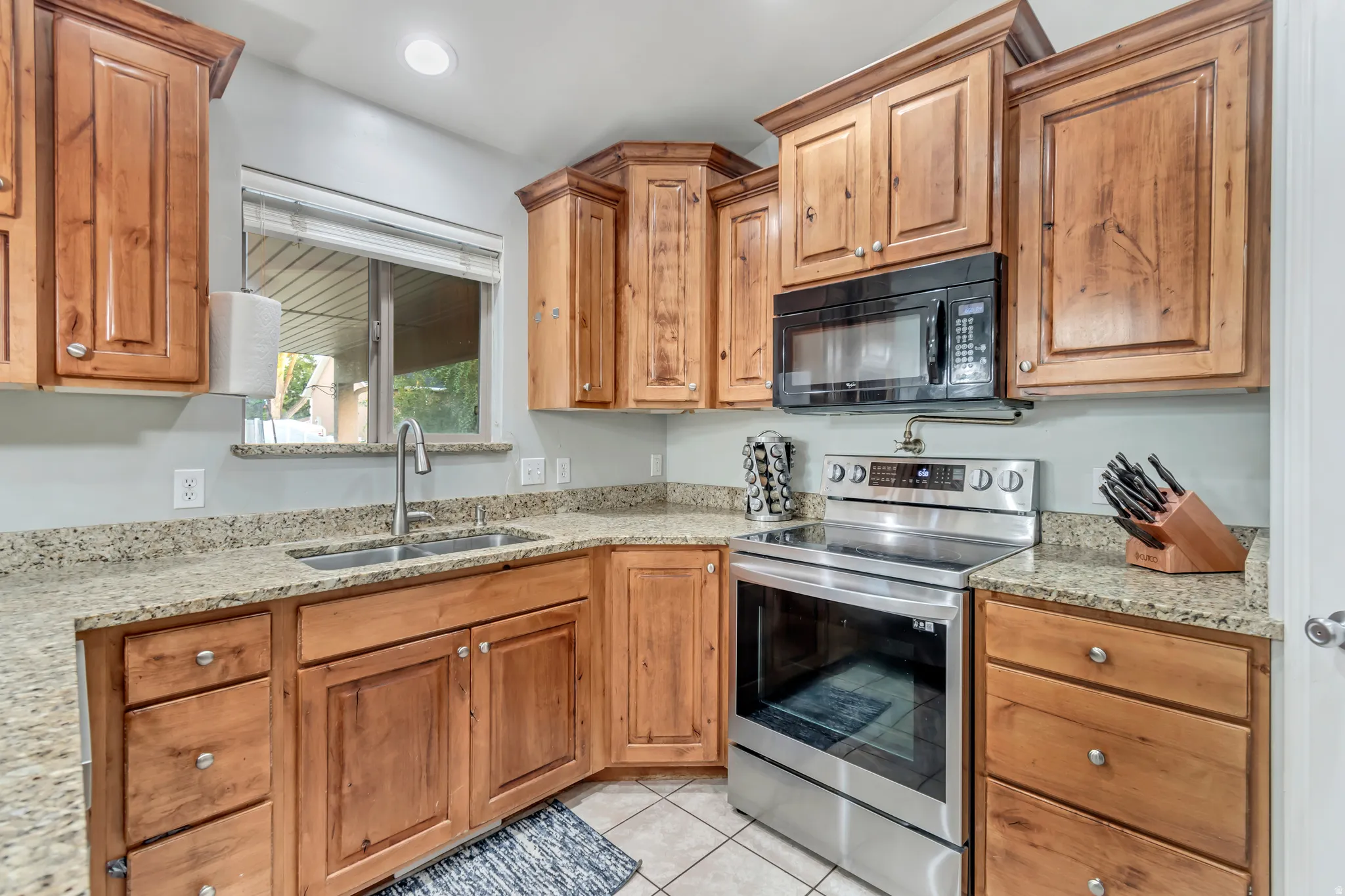 Kitchen with wood cabinetry, granite-finish countertops, and stainless steel appliances