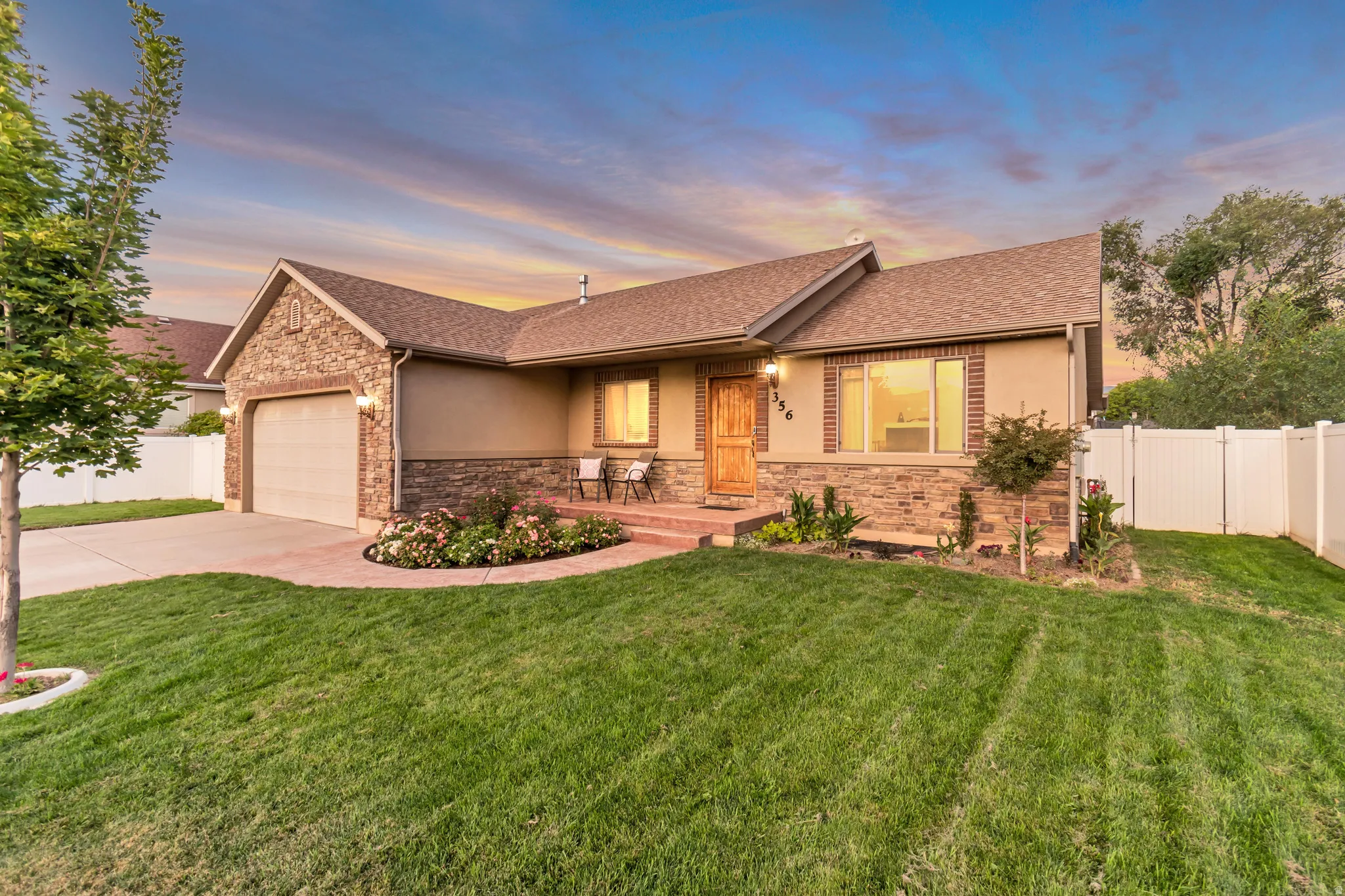 Ranch-style exterior featuring a stucco and stone facade with brick accents
