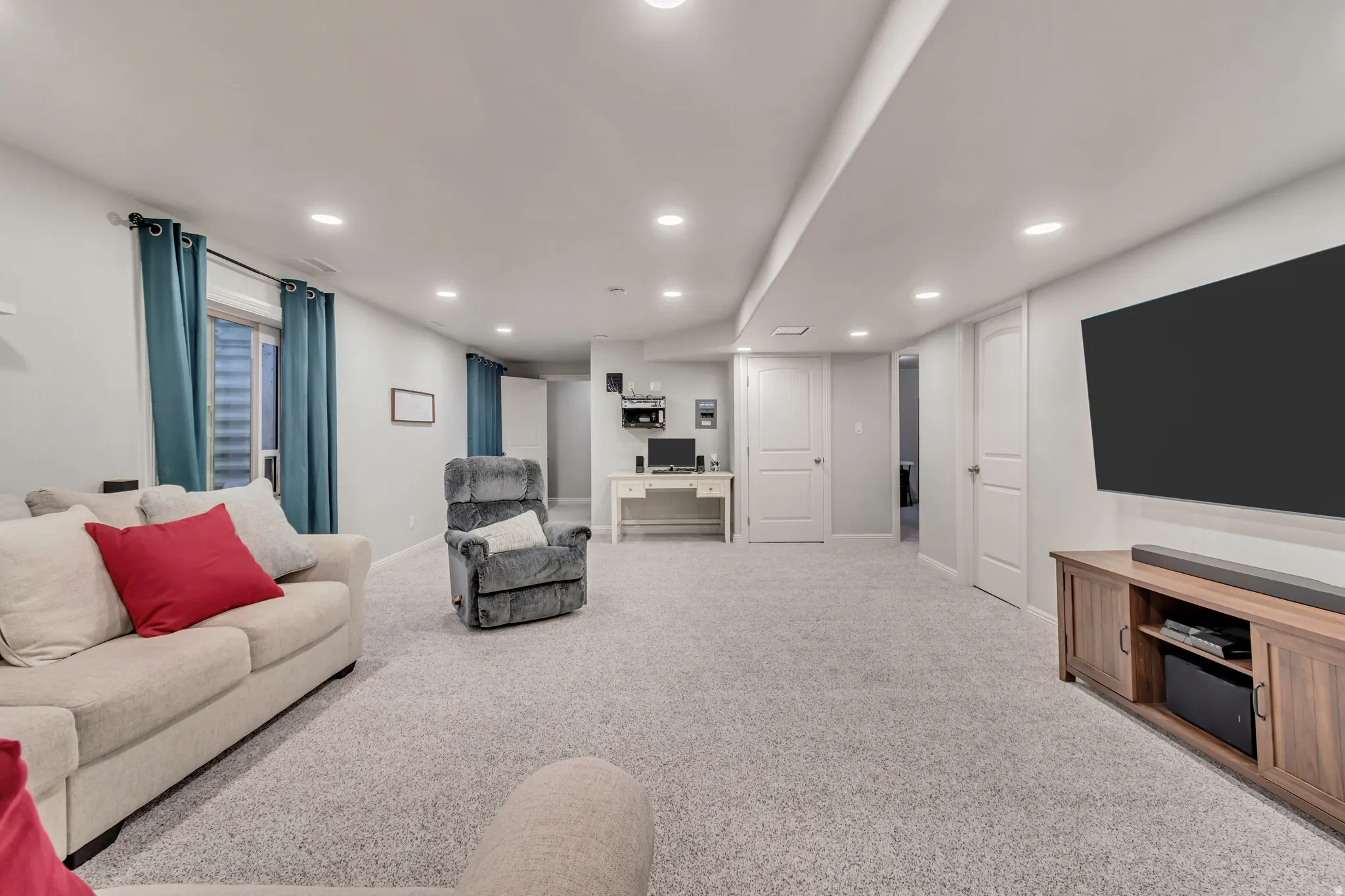 Spacious lower-level area featuring recessed lighting, light gray carpeting, and light-colored walls