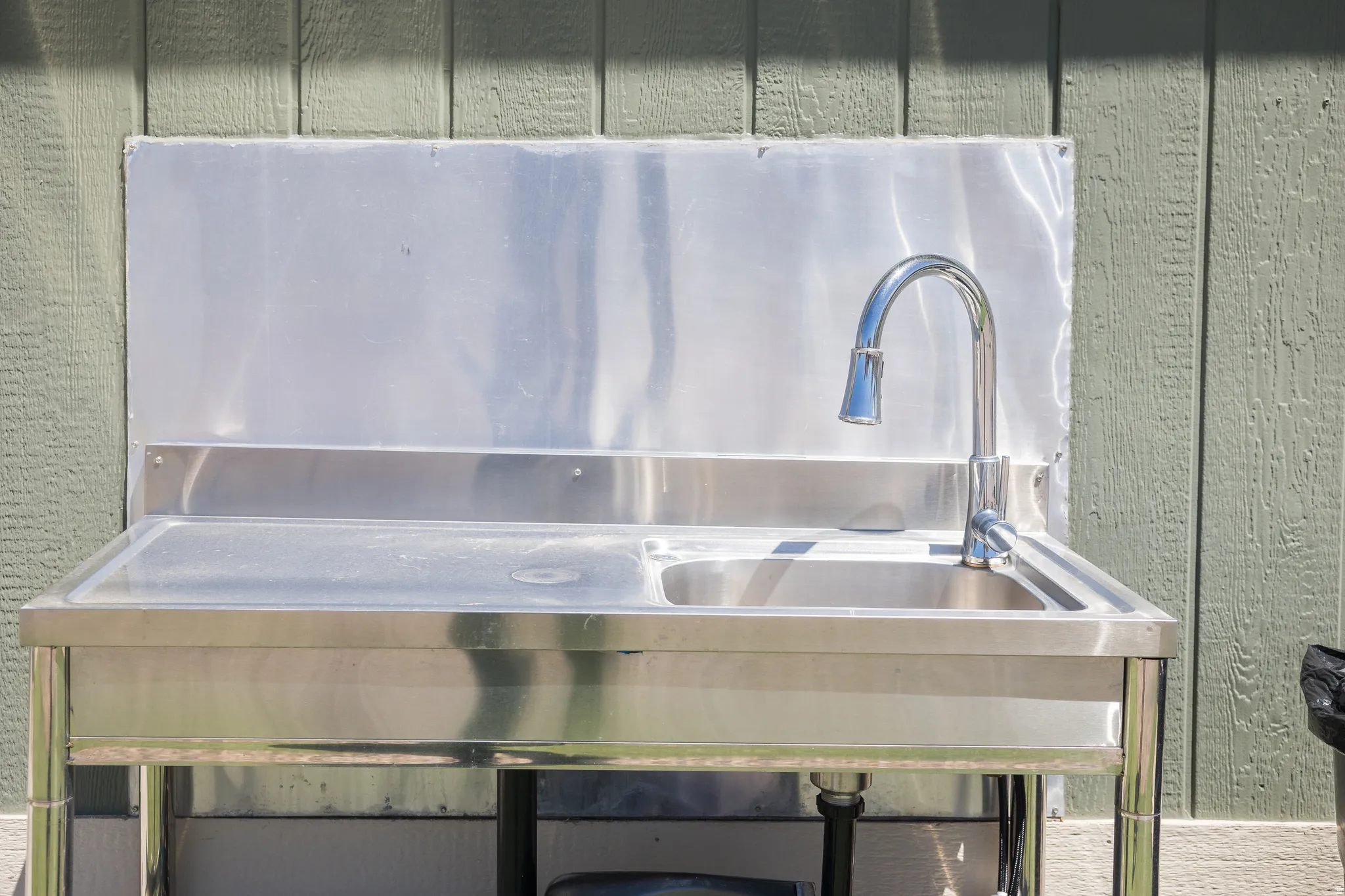 Stainless steel utility sink featuring a polished chrome gooseneck faucet