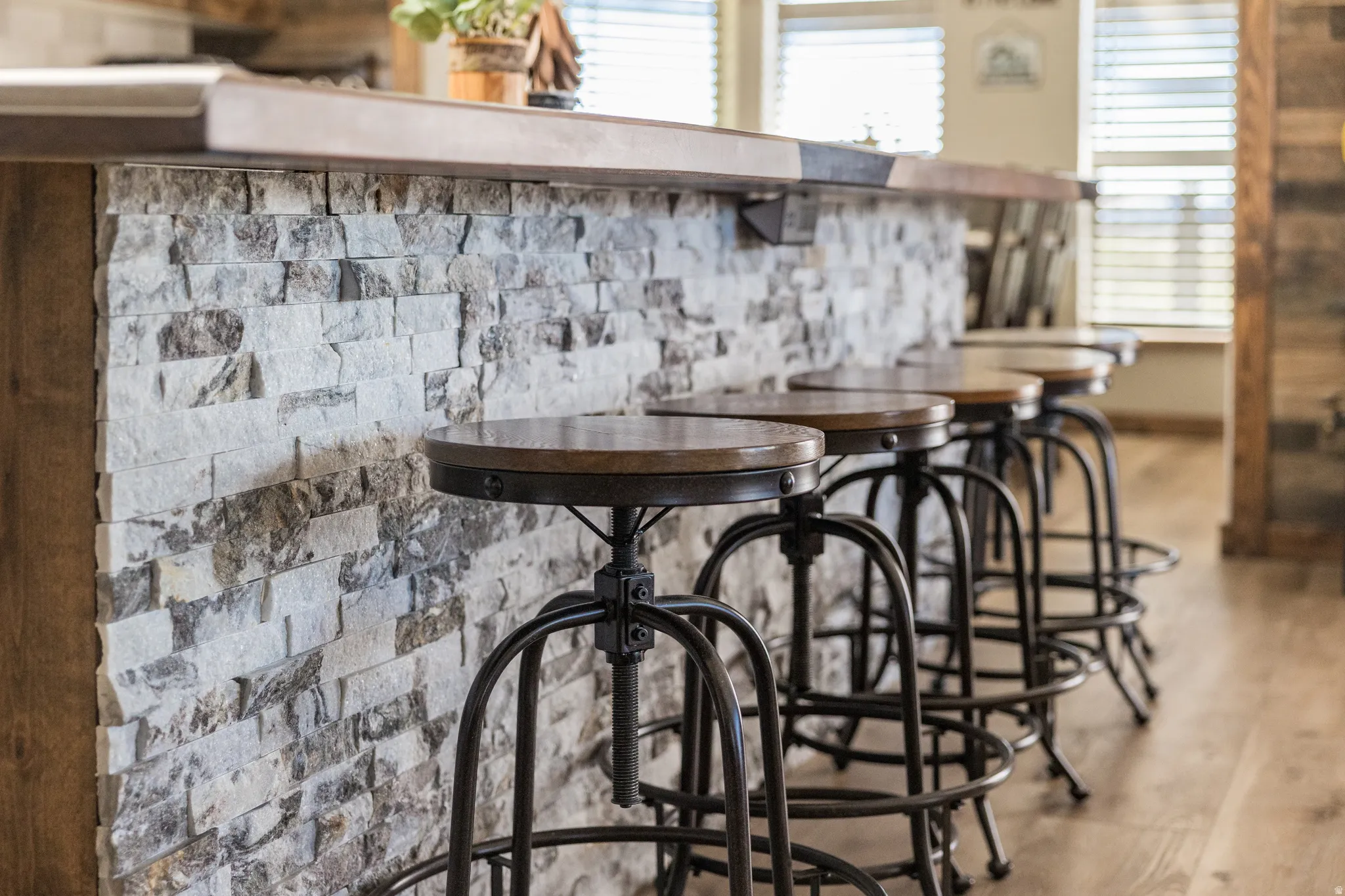 Breakfast bar featuring a stacked stone facade and a wood-finish countertop