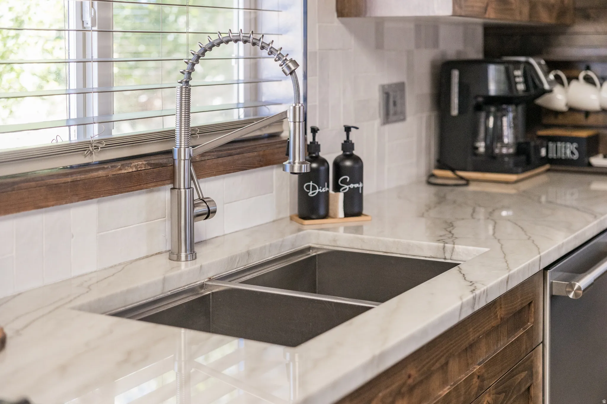 Stainless steel double basin sink with a professional-style pull-down faucet