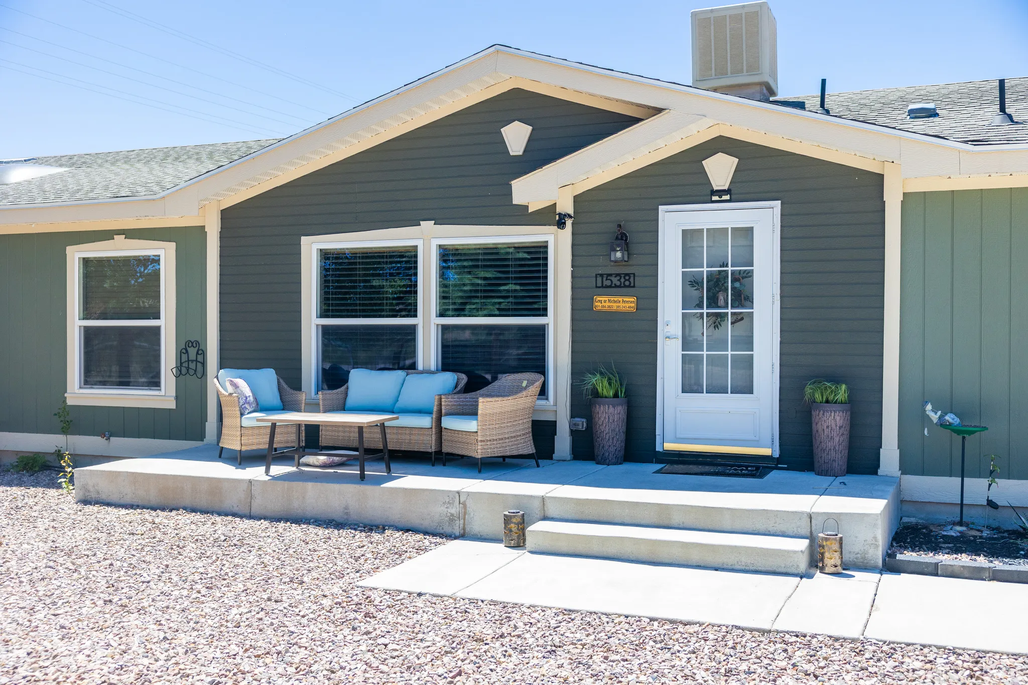 Inviting front porch with concrete steps, siding exterior, and a prominent white entry door with glass panels