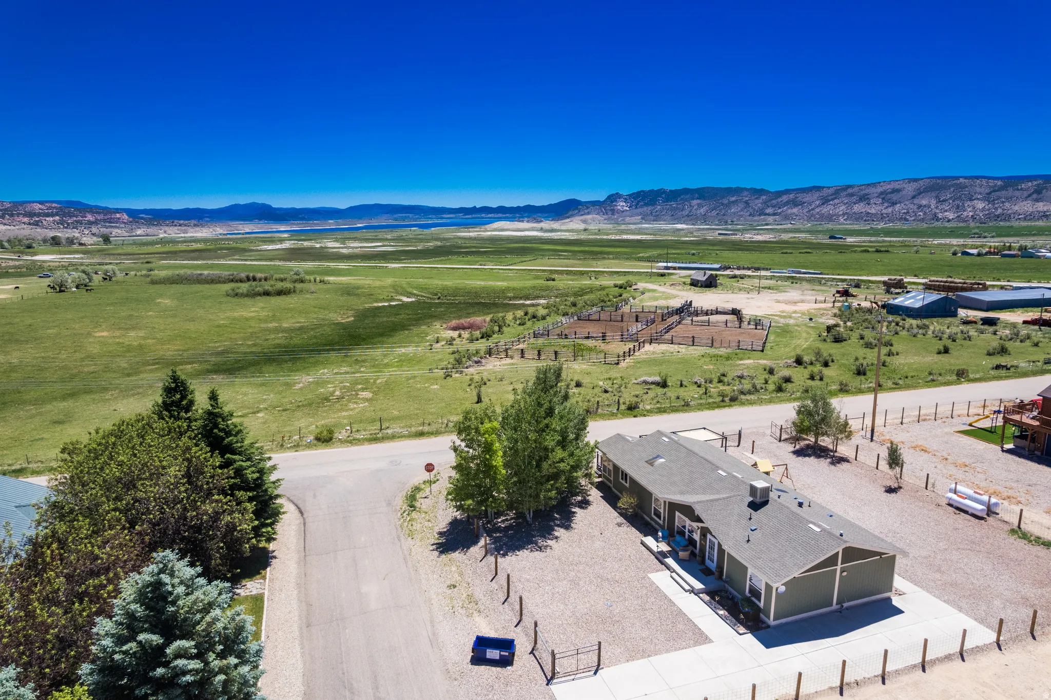 Ranch-style property with expansive surrounding terrain, bordered by a fence line